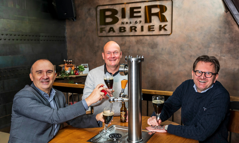 Oprichters bierfabriek aan een taptafel